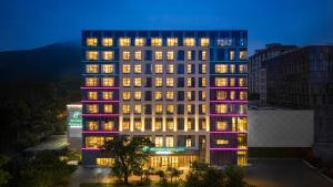 a tall building with lit up windows at night at Holiday Inn Jinan Thousand Buddha Mountain by IHG in Jinan