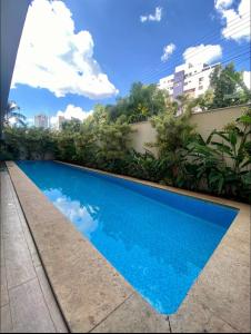 una piscina azul en medio de un edificio en Studio Inn Rami, en Uberlândia