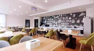 a restaurant with tables and chairs and a chalkboard wall at Green Tree Inn Luoyang Fenghuang Mansion Mudan Square Metro Station in Luoyang