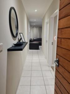 a hallway with a mirror and a couch at 1 Bedroom Luxury Apartment, Beacon Bay North, East London in East London