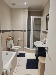 a bathroom with a tub and a toilet and a sink at 1 Bedroom Luxury Apartment, Beacon Bay North, East London in East London