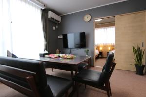 a living room with a table and chairs and a television at Yasuragi-KAWAGOE 2F in Kawagoe
