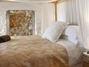 a bedroom with a large bed with white pillows at Snowdrop Cottage in Treffynnon 