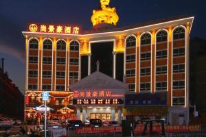 a large building with a lit up tower at night at SHANGJINGHAO HOTEL （SAKATA SNOW ELEPHANT SUBWAY STATION SHOP） in Tiantangwei