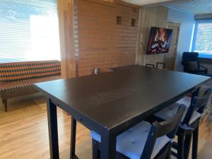 a black table with chairs in a room with a brick wall at Karula Stay 3-Room House in Antsla