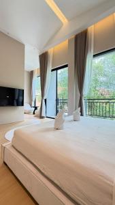 a large bedroom with a large bed with windows at Aura J23A - 8 in Pattaya Central