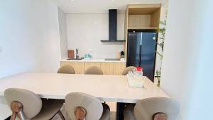 a kitchen with a white table and chairs at Aura J23A - 8 in Pattaya Central
