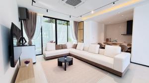 a living room with a white couch and a tv at Aura J23A - 8 in Pattaya Central