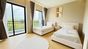 a bedroom with two beds and a balcony at Aura J23A - 8 in Pattaya Central +17 photos