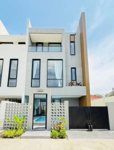 a white house with a black fence at Aura J23A - 8 in Pattaya Central