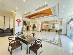 a dining room with a table and chairs in a lobby at Bashan Hotel in Xiamen