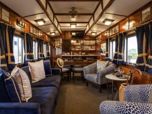 Un vagón de tren con sofás, sillas y una mesa. en Founders Lodge by Mantis, en Paterson