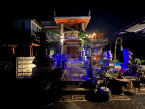 Una casa con luces azules encendidas por la noche en As Family Villa, en Singaraja