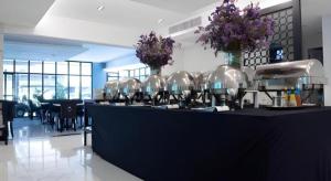 a black counter with vases with flowers on it at Iconic Hotel in Bangkok