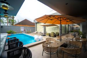 a patio with tables and chairs and a swimming pool at Greyfield Hotel and Apartments in Benin City