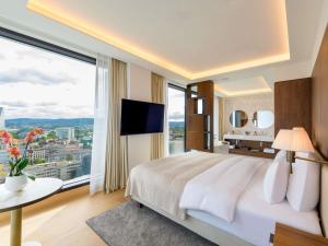 a bedroom with a large bed and a large window at Mövenpick Hotel Basel in Basel