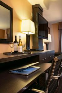 a desk with a laptop and wine bottles and a lamp at Prospector Hotel & Gambling Hall in Ely