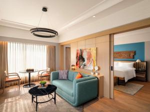 a living room with a couch and a bedroom at Pullman Chennai Anna Salai - Premium Brand By Accor in Chennai