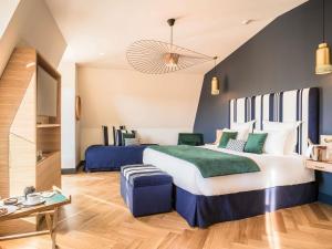 a hotel room with a large bed and a couch at MADISON Saint Jean de Luz - Handwritten Collection in Saint-Jean-de-Luz +194 photos