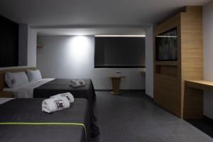 a hotel room with two beds and a flat screen tv at Hotel San Lorenzo in Mexico City +10 photos