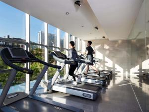 Un hombre y una mujer en una cinta de correr en un gimnasio. en Grand Mercure Shanghai Century Park- Free Shuttle Bus to SNIEC, en Shanghái