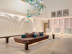 a living room with a couch and a chandelier at Novotel Dubai Gold District in Dubai