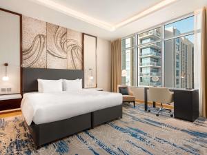 a hotel room with a bed and a desk at Novotel Dubai Gold District in Dubai