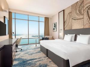 a hotel room with a large bed and a large window at Novotel Dubai Gold District in Dubai +101 photos