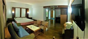 une chambre d'hôtel avec un lit et un salon dans l'établissement Pailyn Phitsanulok Hotel, à Phitsanulok