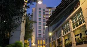 a tall white building with lights on in a city at Grand Surya Hotel Kediri in Kediri