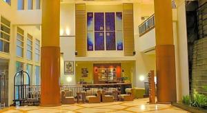 a large building with a lobby with tables and chairs at Grand Surya Hotel Kediri in Kediri