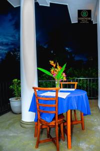 une table avec deux chaises et un vase avec des fleurs dans l'établissement Serendib villa unawatuna, à Unawatuna