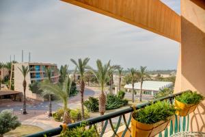 a balcony of a resort with palm trees and plants at Alma in Caesarea