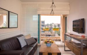 a living room with a leather couch and a table at Alma in Caesarea