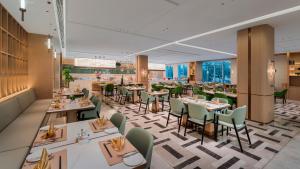 a dining room with tables and chairs at Holiday Inn Jinan Thousand Buddha Mountain by IHG in Jinan