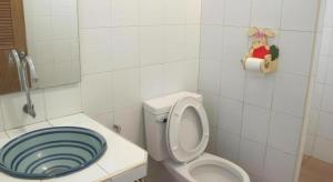 a bathroom with a toilet with a blue lid at Baan Suan Phidchamika in Ban Wat Bot