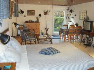 a living room with a bed and a dining room at Chambre d'hôtes Au Canal in Illkirch-Graffenstaden