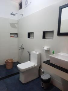 une salle de bain blanche avec toilettes et lavabo dans l'établissement Seashore Beach Resort Varkala, à Varkala