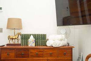 a wooden dresser with towels and a lamp on it at Cosy Rural Barn with Private Garden & Forest - The Cart Barn in Tavistock +29 photos