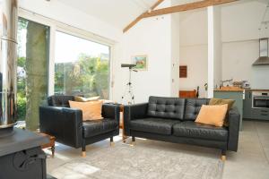 a living room with a couch and two chairs at Cosy Rural Barn with Private Garden & Forest - The Cart Barn in Tavistock