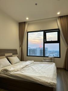 a bedroom with a large bed and a large window at BigSummer House in Long Bình