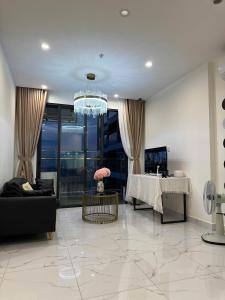 a living room with a table and a chandelier at BigSummer House in Long Bình