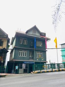 a man standing in front of a green building at Dhanishta Delight in Gangtok