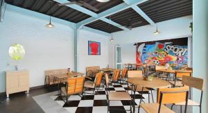 a restaurant with tables and chairs in a room at Umah Bali Suites in Denpasar