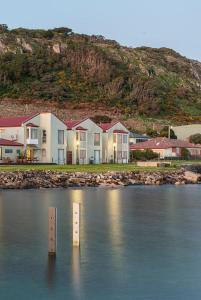 a row of houses on the shore of a body of water at Stanley Village Waterfront Accommodation in Stanley