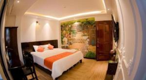 a bedroom with a bed and a painting on the wall at Laverne Hotel in Ho Chi Minh City