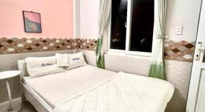 Ly SonにあるLoc Thinh Motelの窓のある白いベッドのある寝室 +1枚の写真