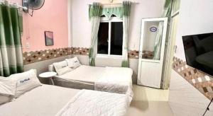 Ly SonにあるLoc Thinh Motelのベッドが2つとテレビがある部屋