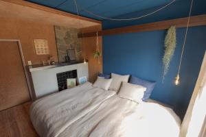 a bedroom with a large bed with a blue wall at La toile in Mitoyo