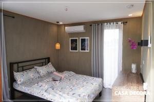 ein Schlafzimmer mit einem Bett und einem Fenster in der Unterkunft Casa Decora in Bamban